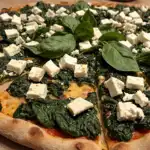 The Ultimate Spinach and Feta Pizza: An awesome delicious Mediterranean Masterpiece 2 spinach and feta pizza served fresh on a rustic board