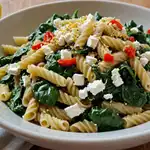 Spinach and Feta Pasta: a Simple Fusion of Flavor and Tradition 2 Spinach and feta pasta served in a rustic Mediterranean bowl