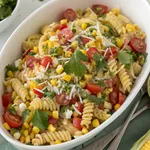 7 Amazing Elote Pasta Salad Secrets Every Home Cook Must Know 2 Elote pasta salad with charred corn, cotija cheese, and cilantro in white bowl on wooden table