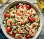 Protein-rich shrimp and white bean salad featuring Mediterranean ingredients like feta, tomatoes, and fresh herbs