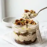Spoonful of creamy Mediterranean overnight oats showing layers of yogurt, oats, figs, and walnuts