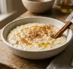 Mediterranean Rice Pudding (Serves 6) 1 Mediterranean rice pudding single serving ramekin with cinnamon honey and spoon 45 degree angle