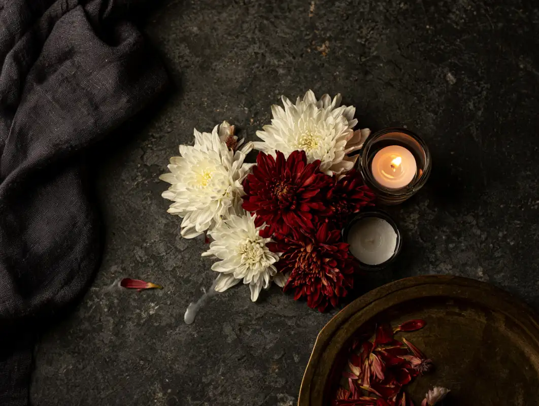 home 7 Candlelit Italian table set for Ognissanti with dark bakes, a jug of water and chrysanthemums to answer the question : do italians celebrate halloween